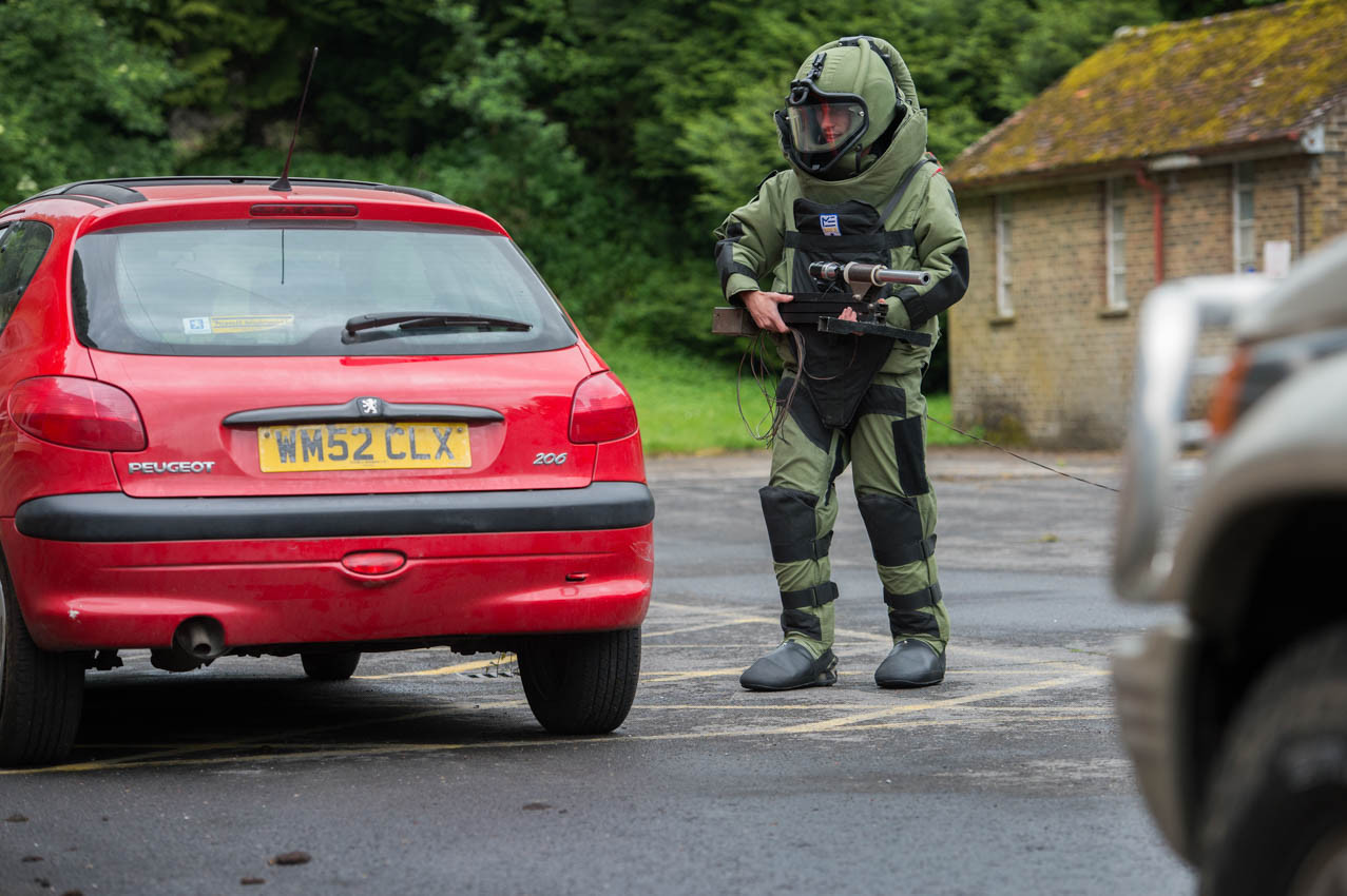 An improvised explosive device disposal specialist searching a car as part of IEDD training